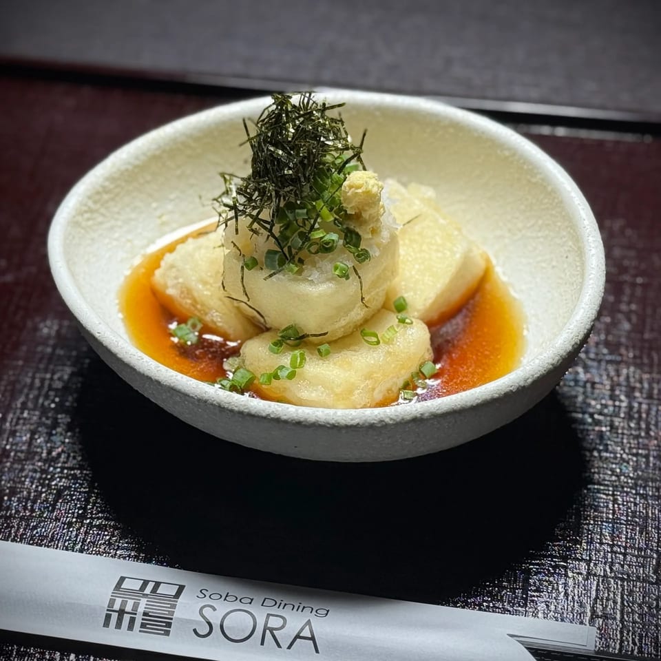 Japanese fried tofu topped with grated daikon, green onions, and seaweed in savory broth at Soba Dining Sora.